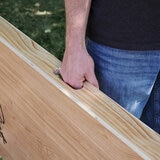 Lifestyle image showing someone using the carry handle to carry the Cornhole