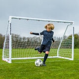 Lifestyle image of a goalkeeper kicking a football away from the goal