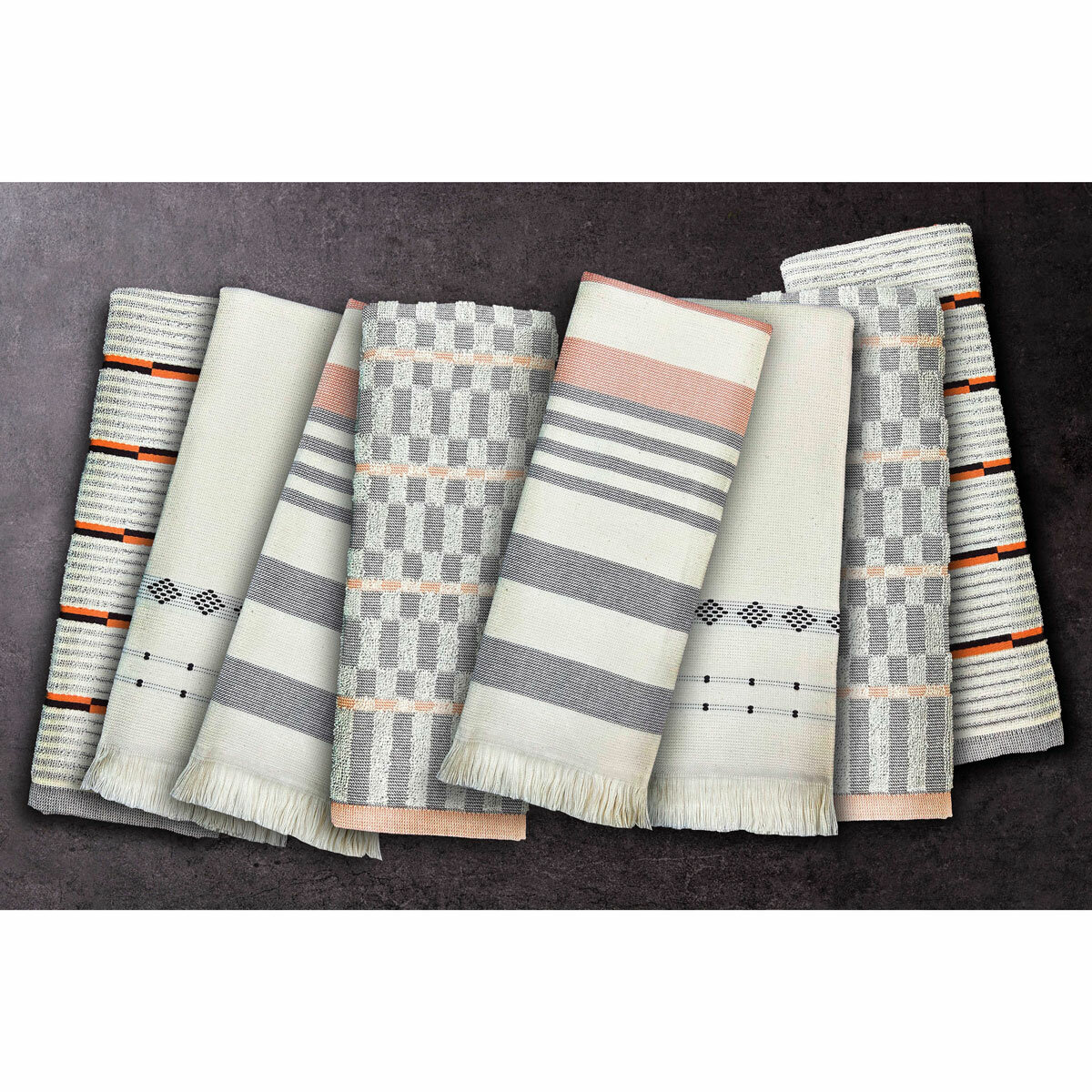 Set of eight folded woven tea towels in grey, beige and orange geometric and striped patterns, arranged to show their weave and detail