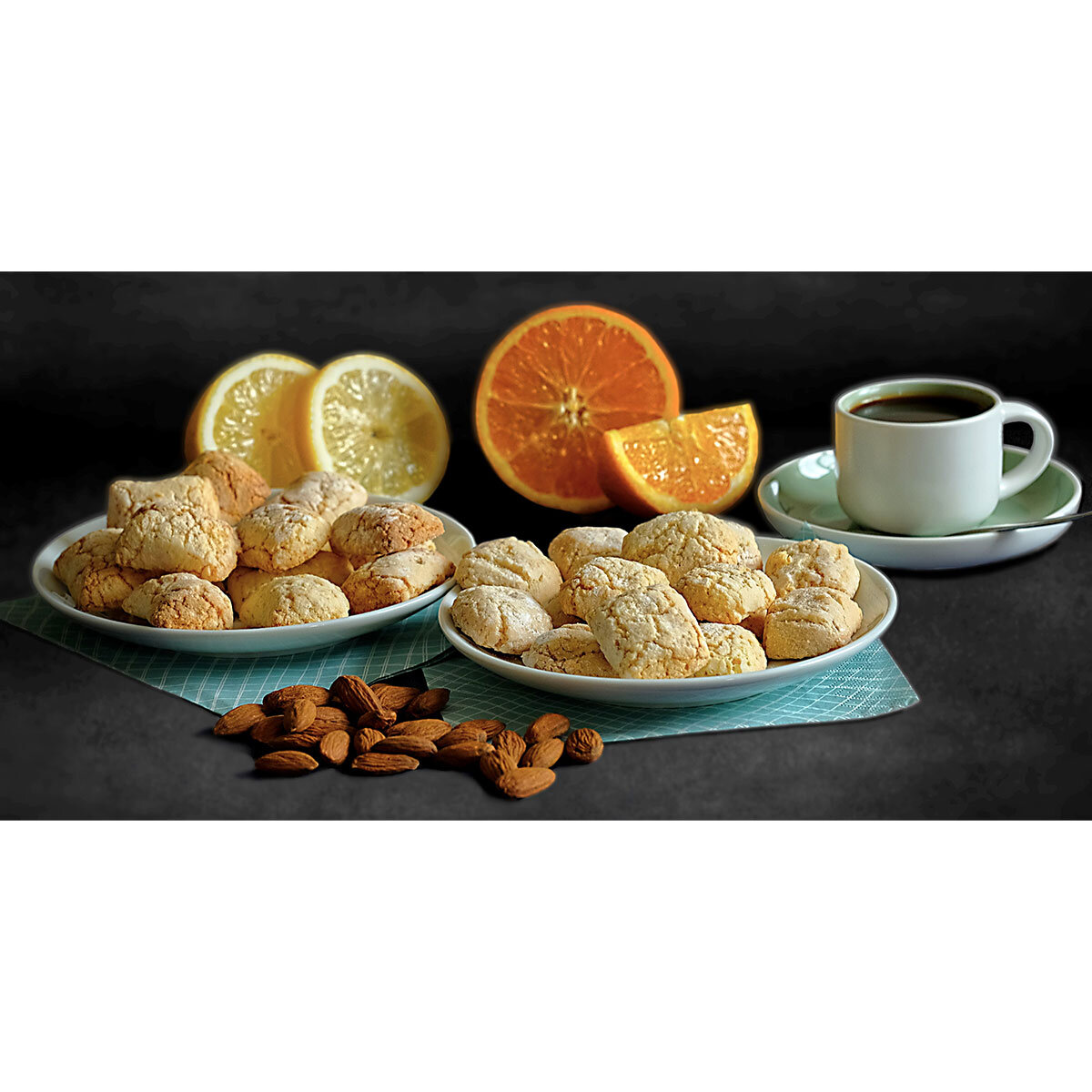 Orange and Lemon Biscottini Bites on a plate with lemons and oranges behind