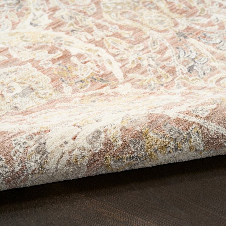 Pink and beige patterned rug with vintage-style floral and geometric motifs
