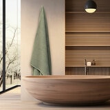 Light green textured bath sheet hanging on a wall hook in a modern bathroom.