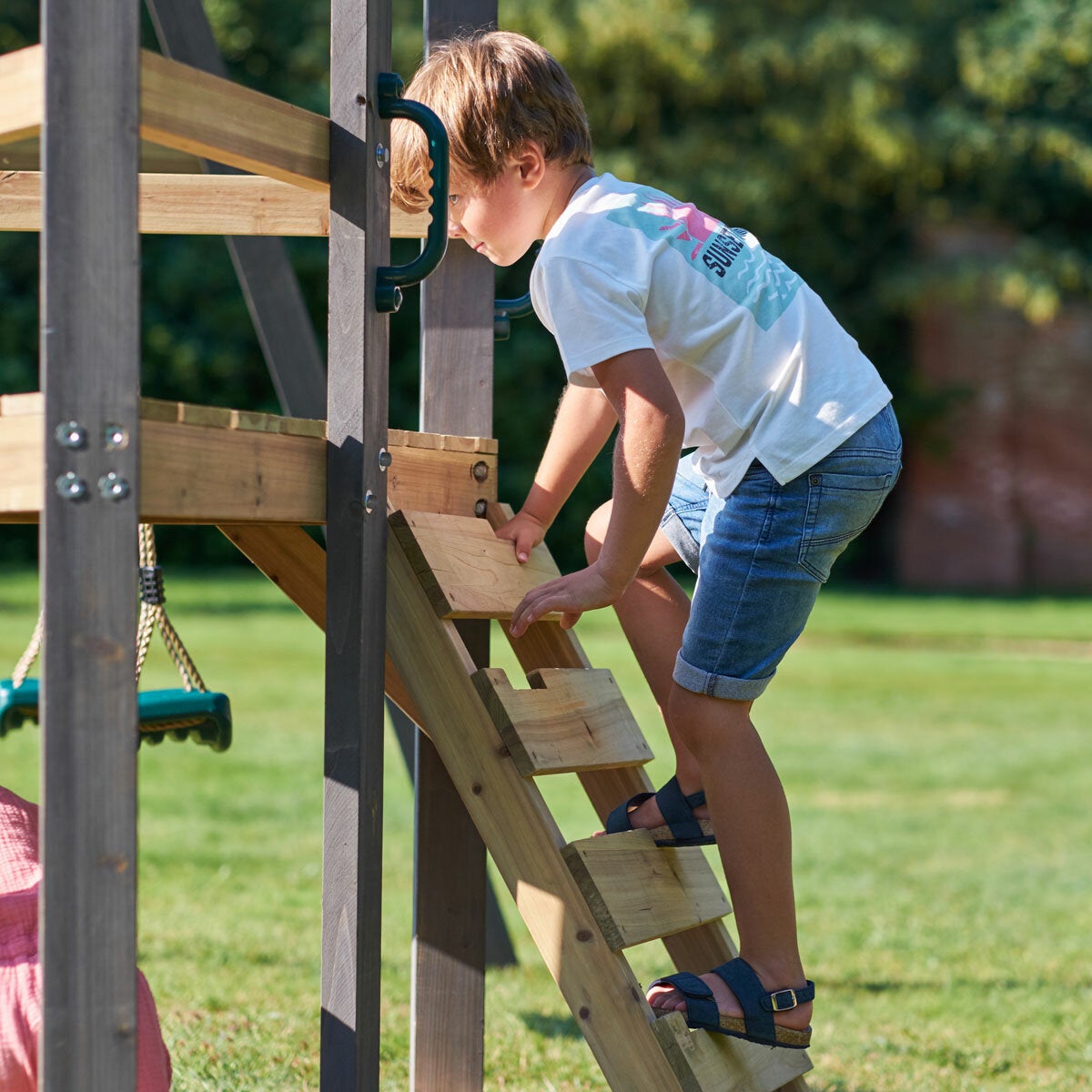 A lifestyle image of a child climbing the latter A lifestyle image of a child climbing the latter